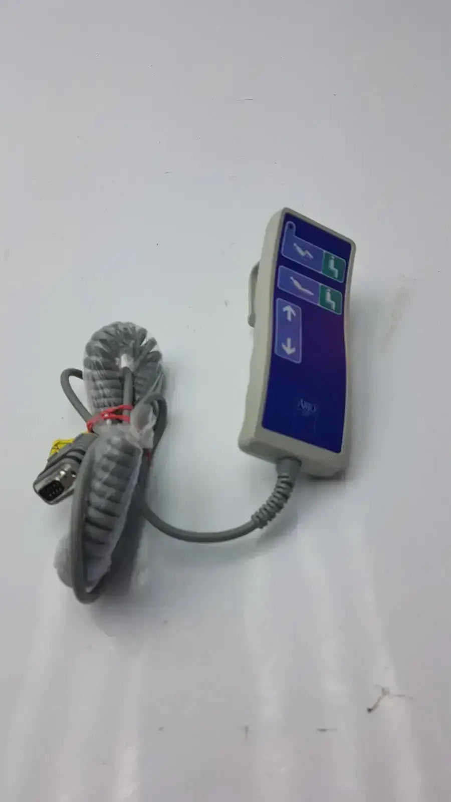 Gray coiled cable connected to beige arjo huntleigh patient lift remote handset with blue and green directional buttons