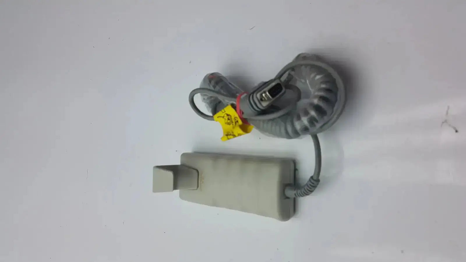 Gray coiled cable with rectangular connector and yellow tag for arjo huntleigh patient lift remote handset
