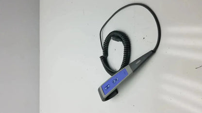 Black coiled cable attached to a gray and blue handheld arjo huntleigh patient lift wired remote handset controller