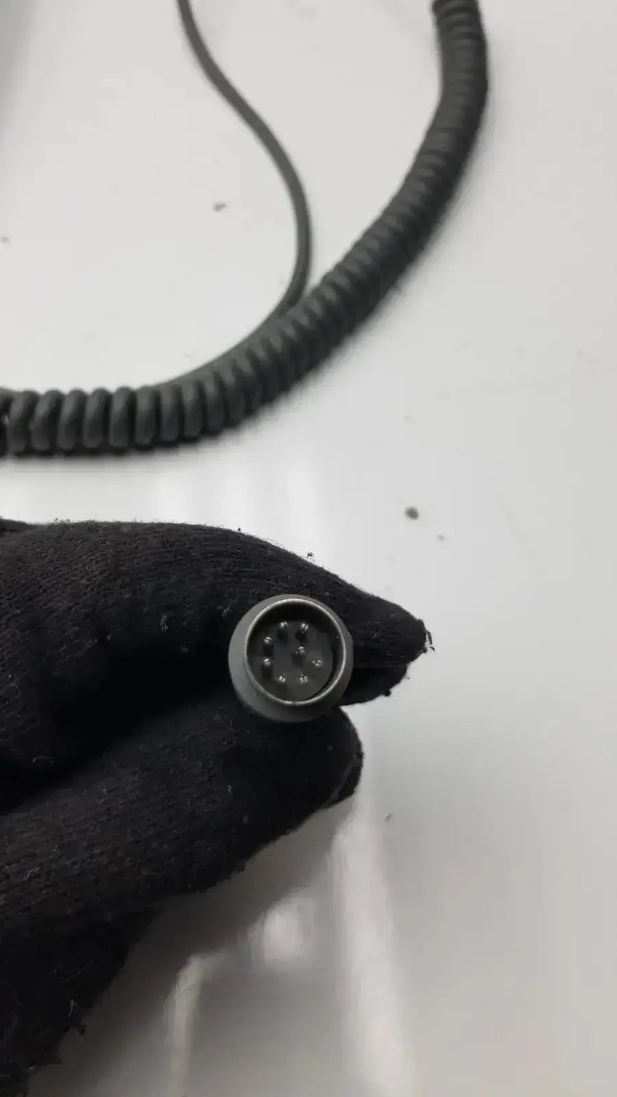Black coiled cable connector with circular metal housing and multiple pin contacts for arjo huntleigh patient lift handset controller
