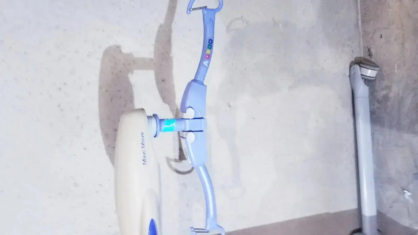 Light blue and white stationary exercise bike with curved handlebar design for arjo maxi power patient lift use