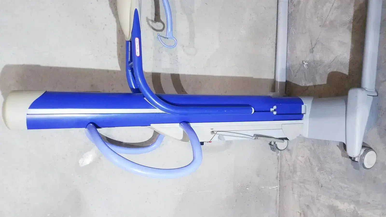 Blue and white arjo maxi power patient lift with adjustable height mechanism for safe patient transfer