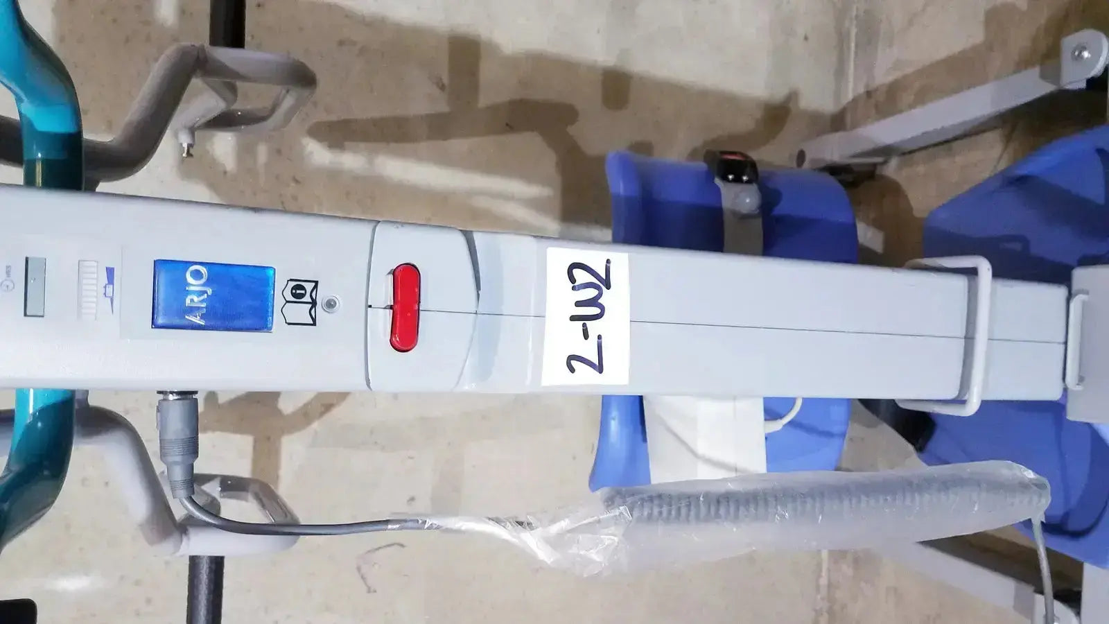 White arjo sara 3000 hospital mobile patient standing raising lift aid with blue and red control buttons on blue panel