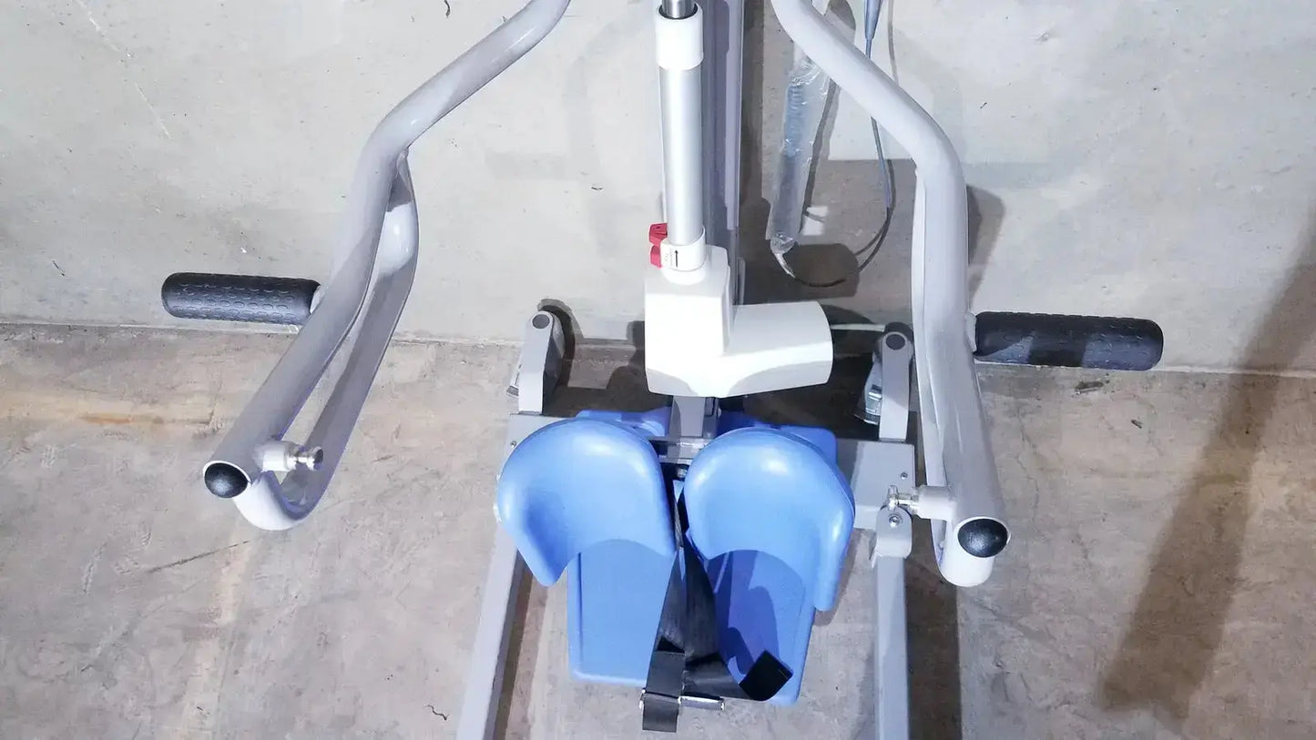 Gray metal-framed arjo sara 3000 hospital mobile patient standing raising aid with blue footrests and black grip handles