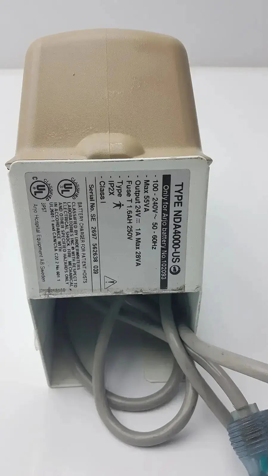 Beige plastic arjo type nda4000-us charger 100-240v with gray cables and input 24v dc 1a output label visible