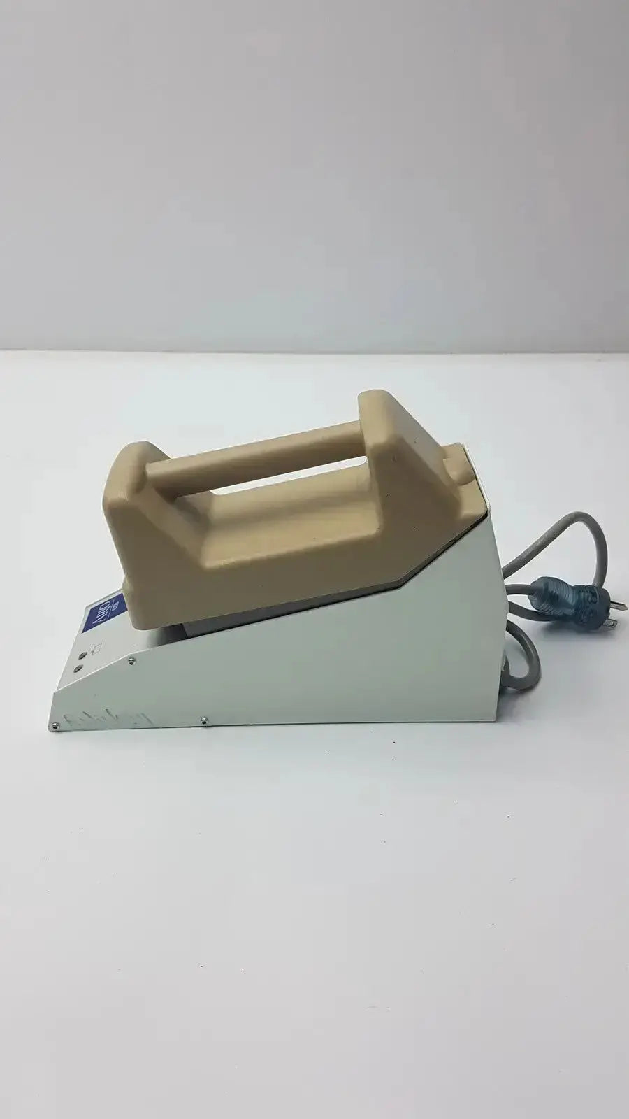 Beige and gray handheld ironing station with molded handle featuring arjo type nda4000-us charger 100-240v input 24v