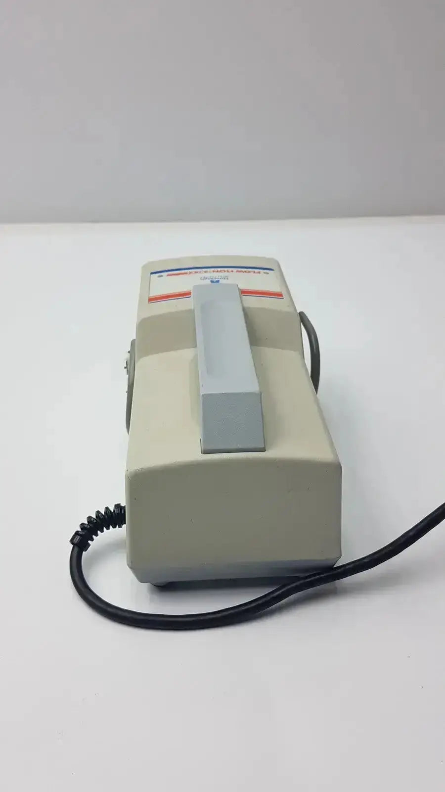 Beige plastic handheld arjohuntleigh flowtron excel model ac 550 with gray handle and black coiled cord