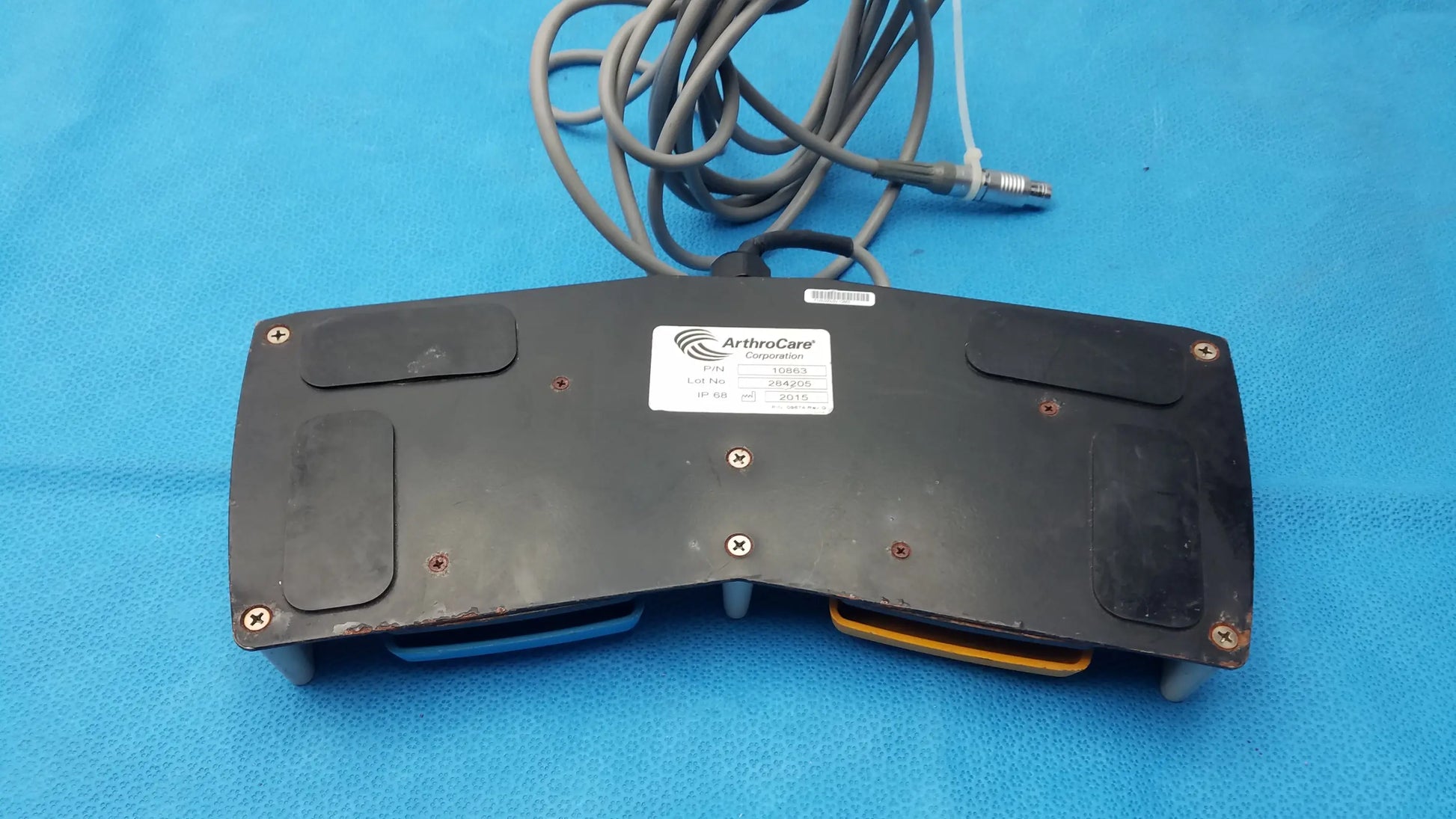 Arthrocare 10863 dual footswitch pedal in black with coiled gray cable and yellow accents for pre owned medical equipment sale