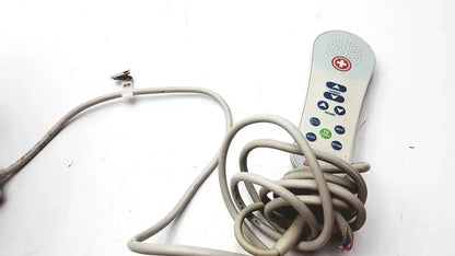 Gray plastic remote control with red cross and multiple buttons with coiled cable for hc-pspkr-da-d2 patient response system