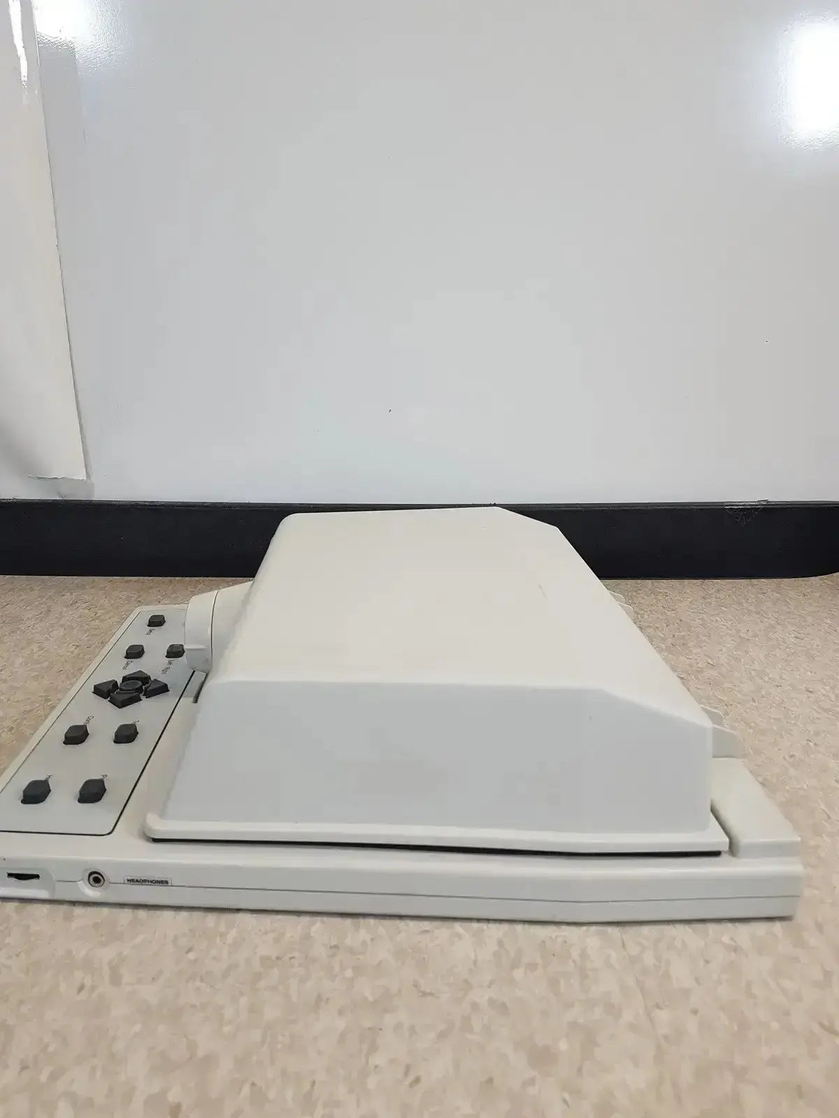 Off-white plastic audioscan verifit vf-1 hearing aid analyzer with rectangular lid and black control buttons on left side
