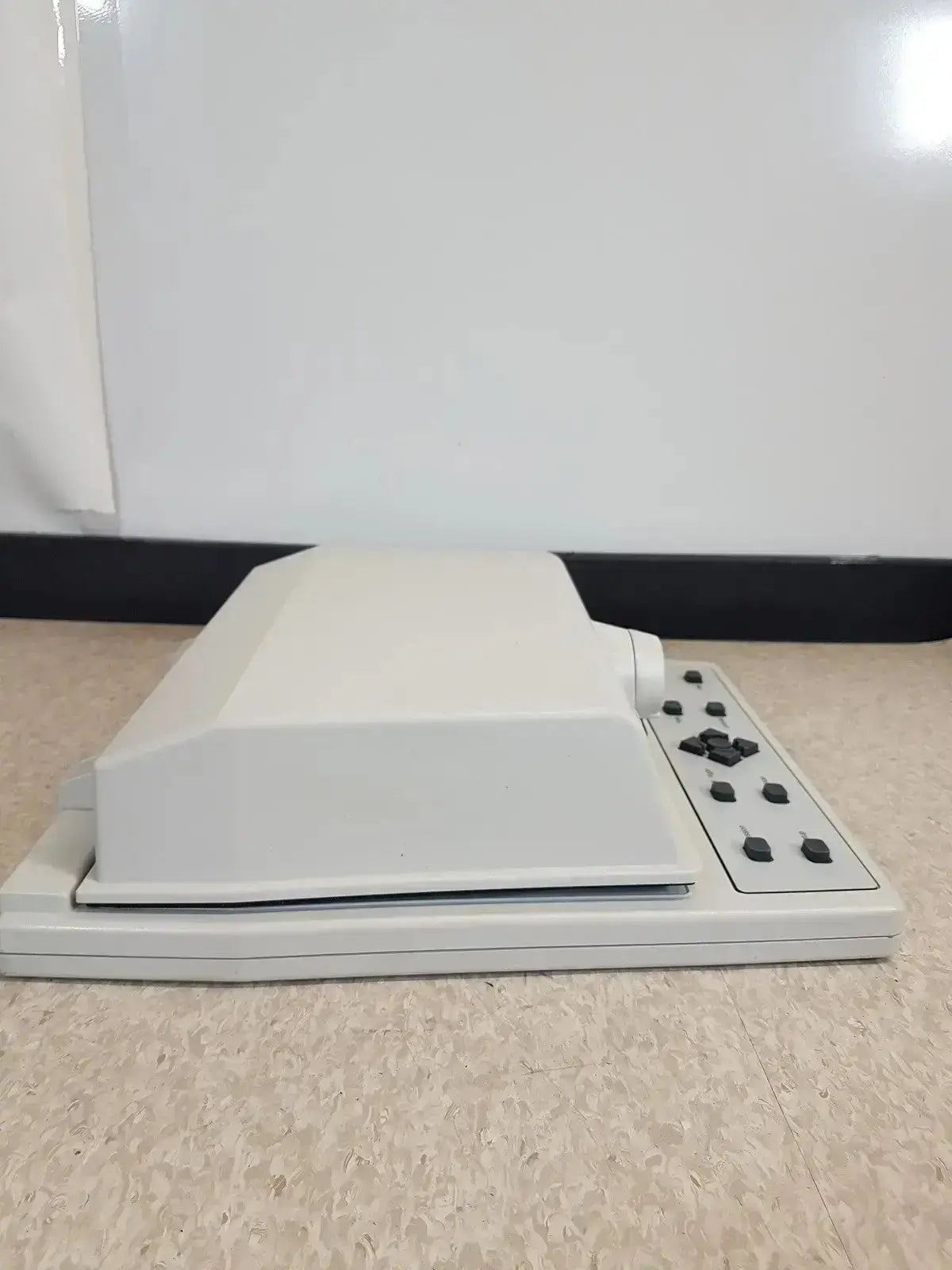 White plastic desktop audioscan verifit vf-1 hearing aid analyzer with rectangular lid and black control buttons on right side