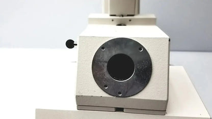 Beige-colored microscope base of axiovert 35 inverted phase contrast microscope with black metal port and knob side view