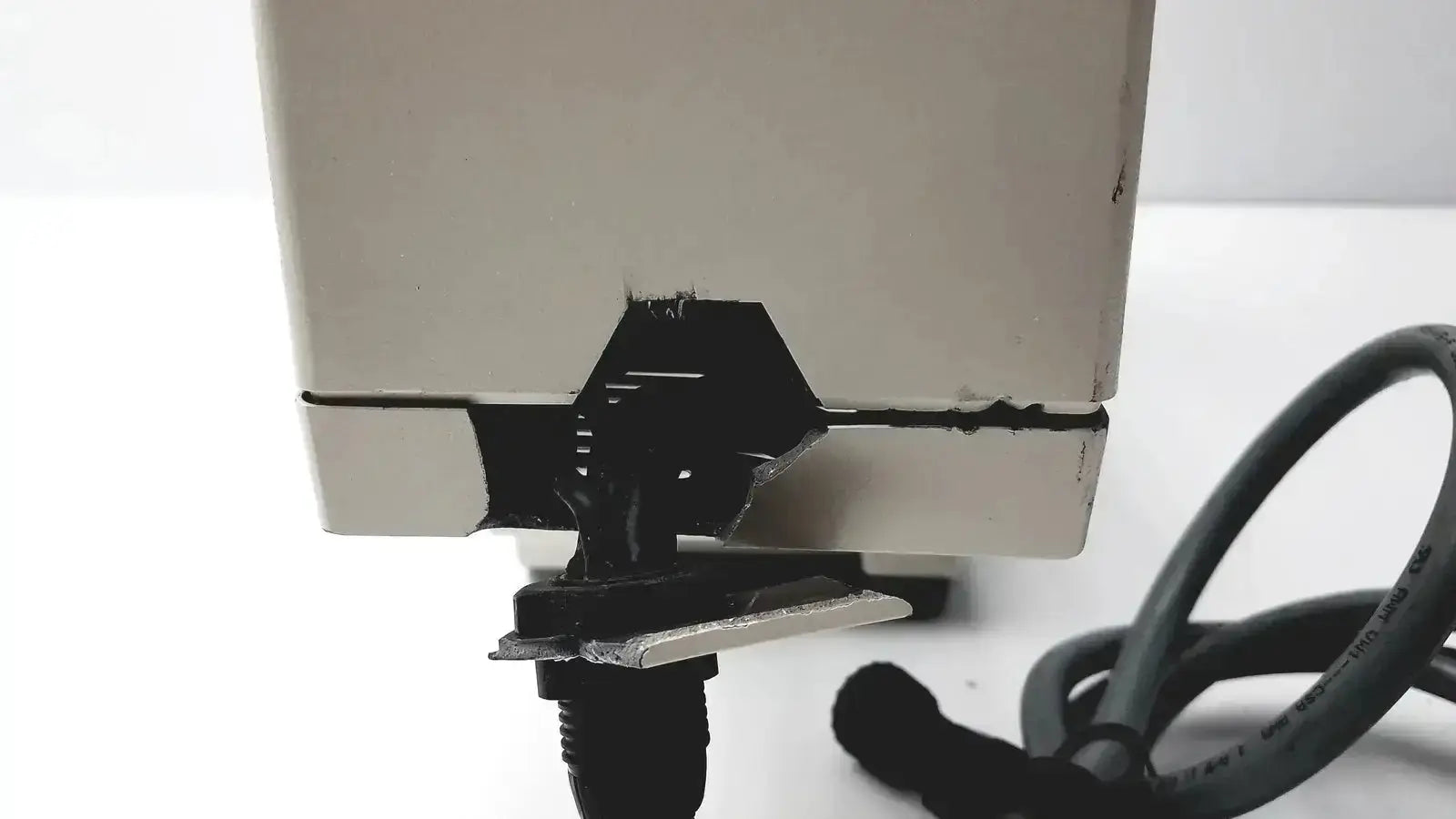 Beige plastic axiovert 35 inverted phase contrast microscope showing black damaged hinge and attached black cable on back side