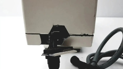 Beige plastic axiovert 35 inverted phase contrast microscope showing black damaged hinge and attached black cable on back side