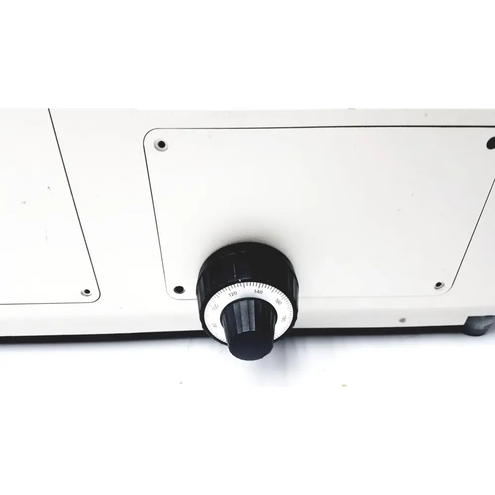 Black rotary dial with white numbered scale mounted on a white panel.