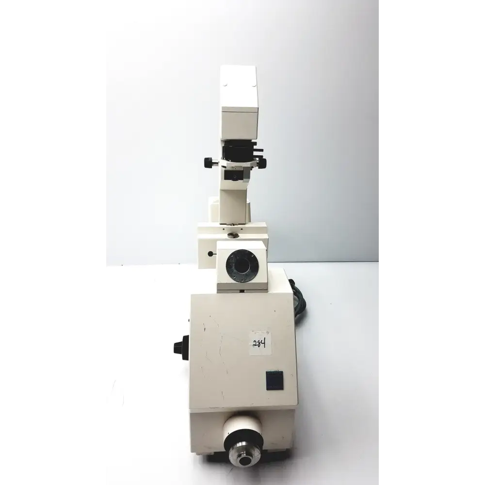 White, sturdy metal microscope with black adjustment knobs and a circular stage.