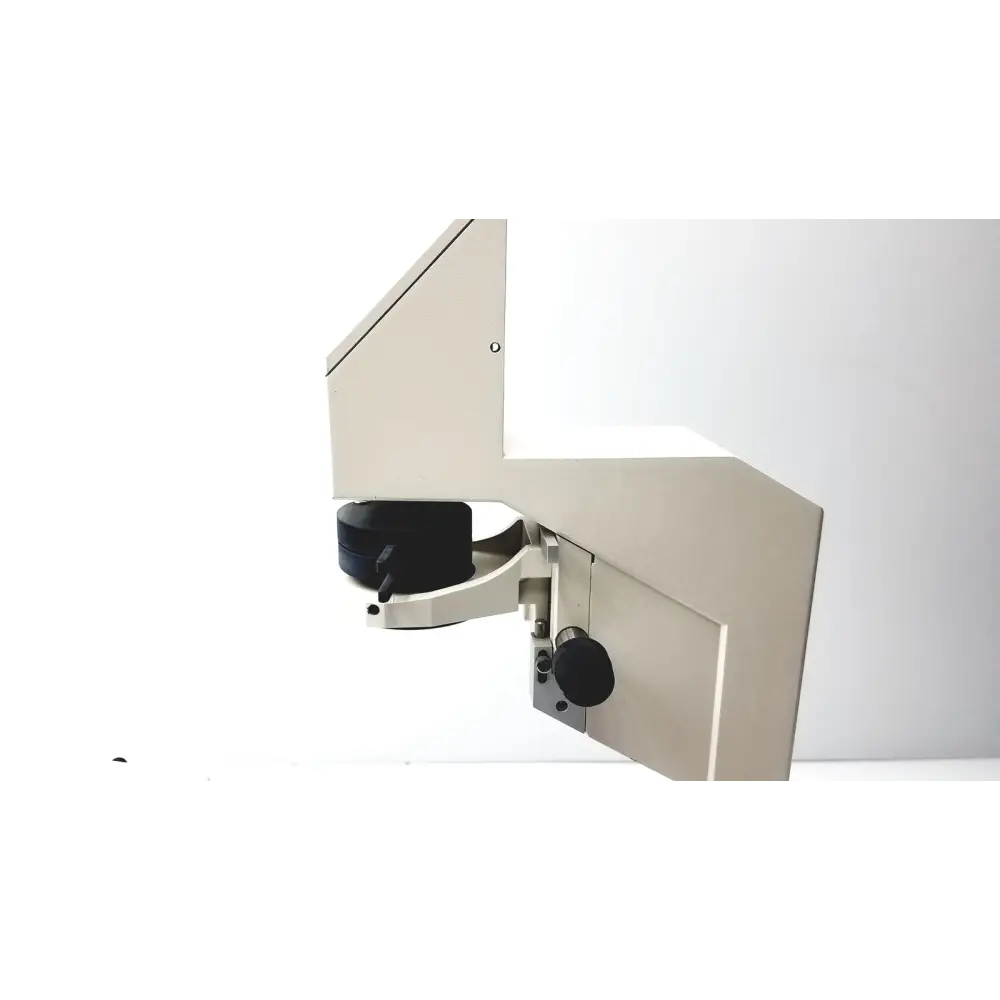 Beige metallic industrial microscope with black adjustment knobs and a sleek, angular design.