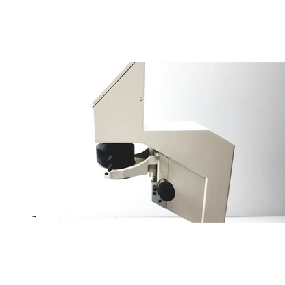 Beige metallic industrial microscope with black adjustment knobs and a sleek, angular design.
