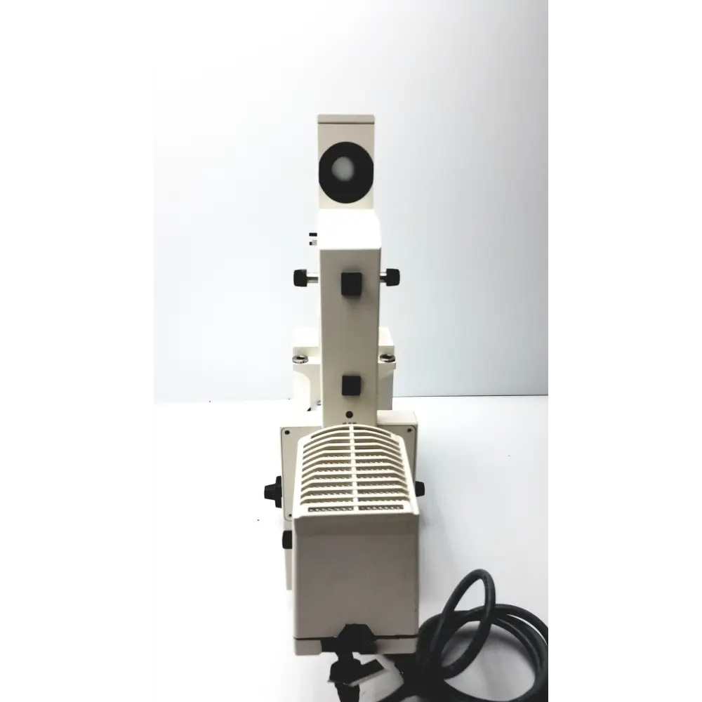 White metal microscope with black knobs and a circular eyepiece.