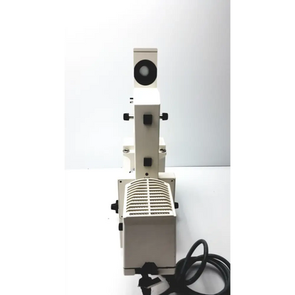 White metal microscope with black knobs and a circular eyepiece.