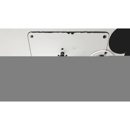 White metal plate with black screw holes and a circular component nearby