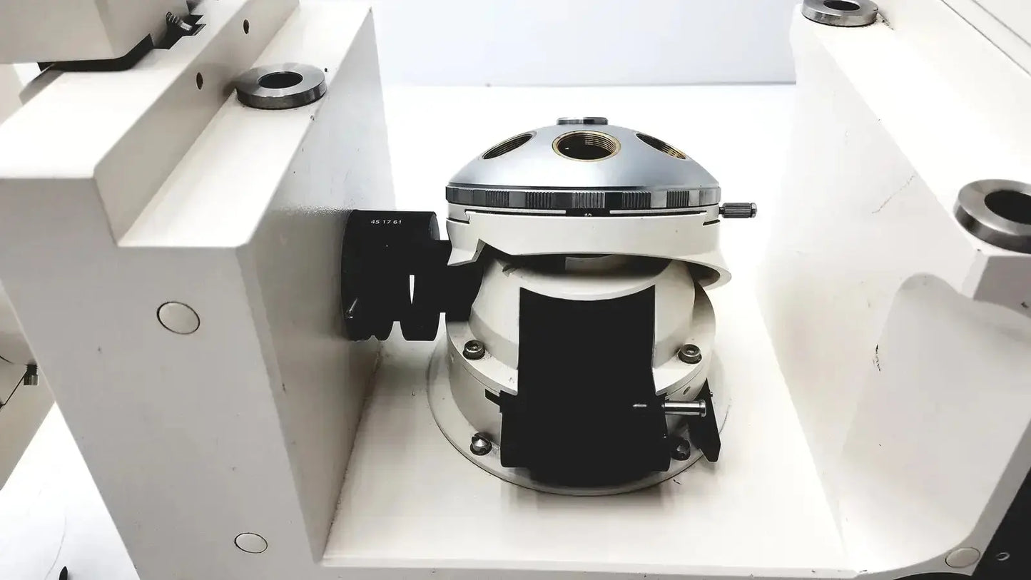 Silver and white mechanical camera lens mount with black rubberized grips on the back of axiovert 35 inverted phase contrast microscope
