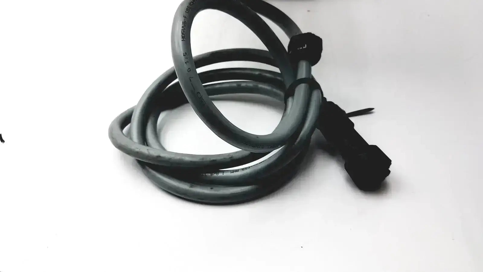 Black coiled cable with black connector end at the back of an Axiovert 35 inverted phase contrast microscope