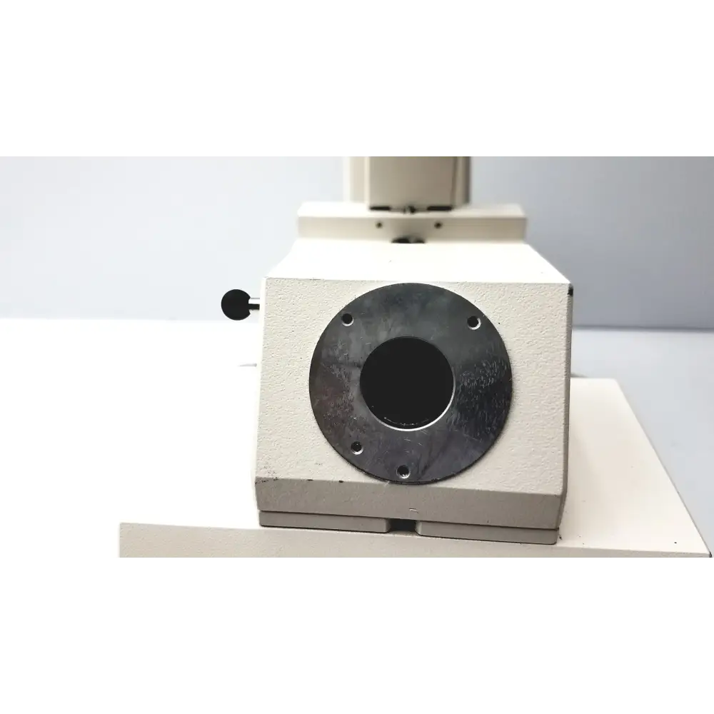 Beige metal microscope stage with a circular black mounting plate and four screw holes.