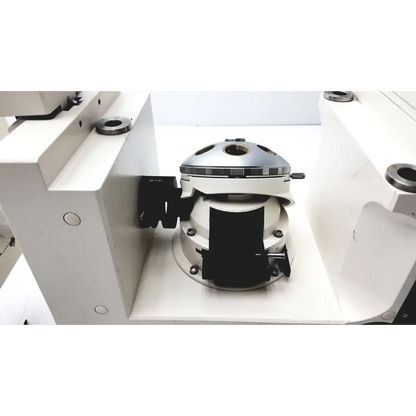 Silver and white industrial machine component with black clamps