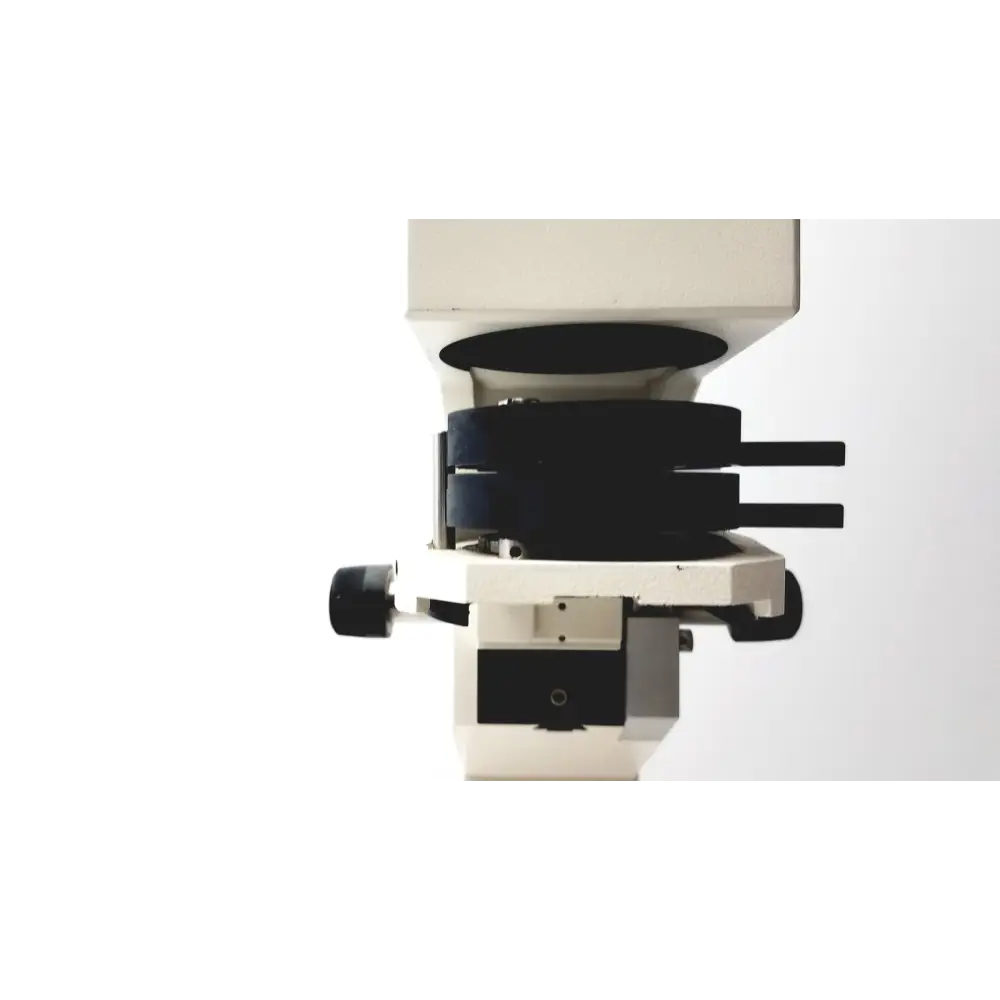 White laboratory microscope with black objective lens turret and stage clips