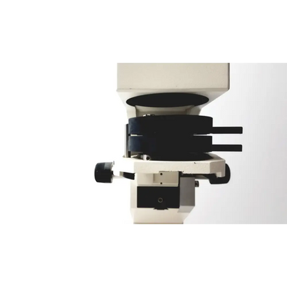 White laboratory microscope with black objective lens turret and stage clips