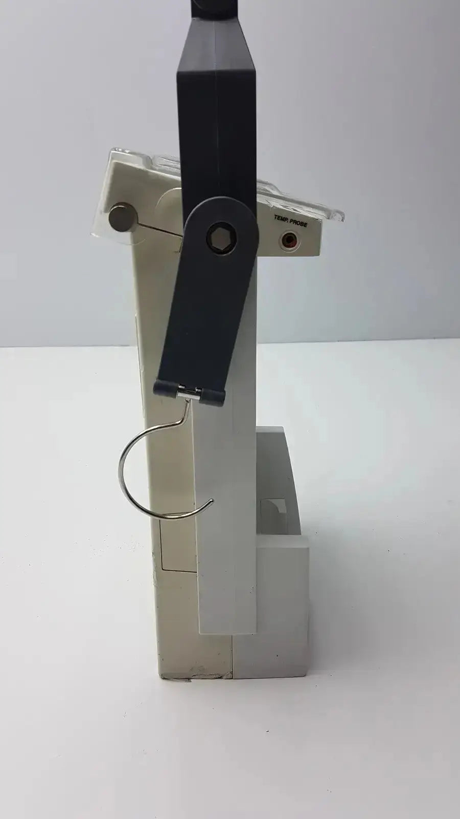 Black and beige plastic clamp with metal hook for bard criticore fluid output and temperature monitor 000002n