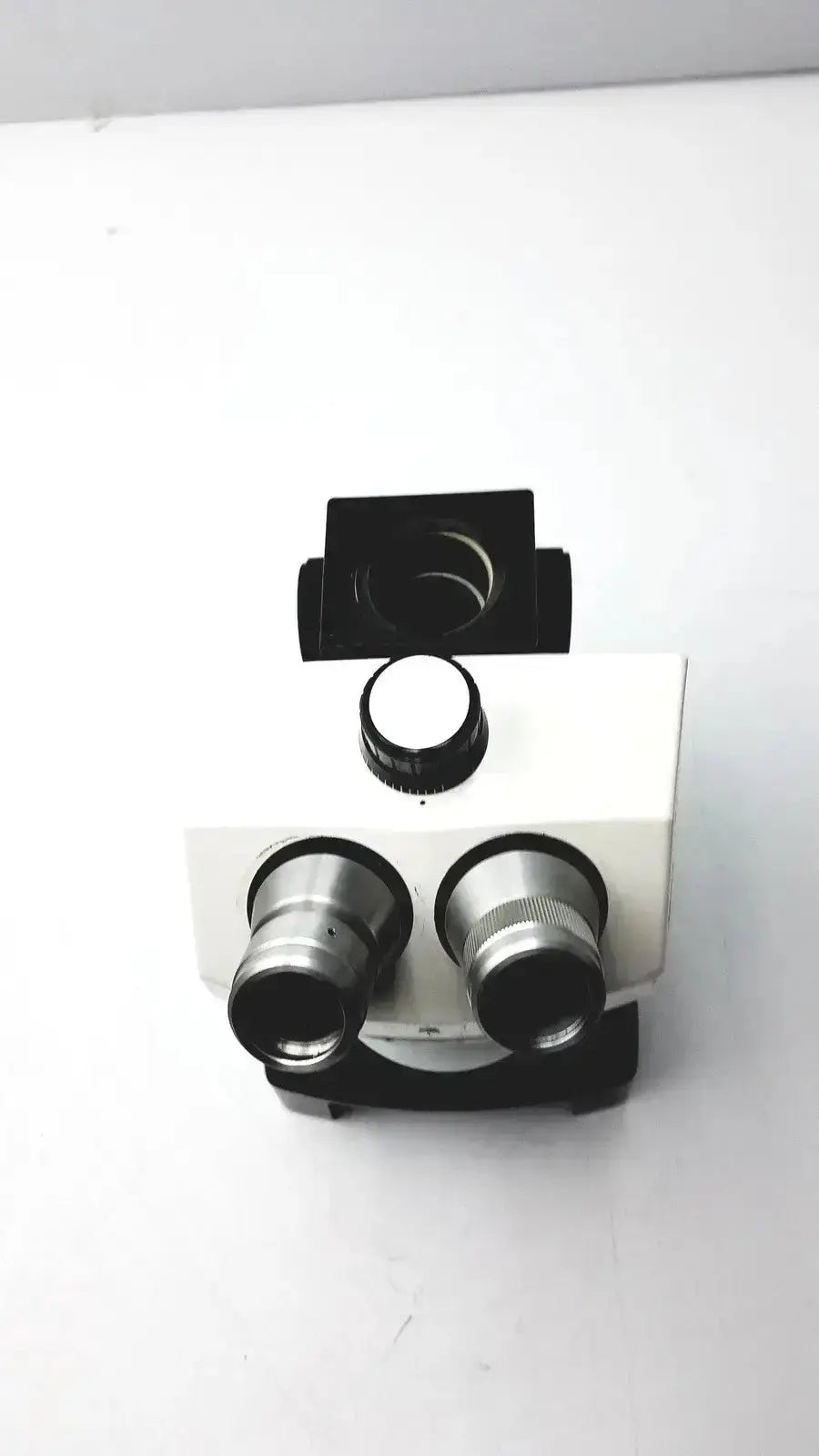 White and black bausch and lomb microscope with dual eyepieces and stage for biomedical evaluation from hospital surplus