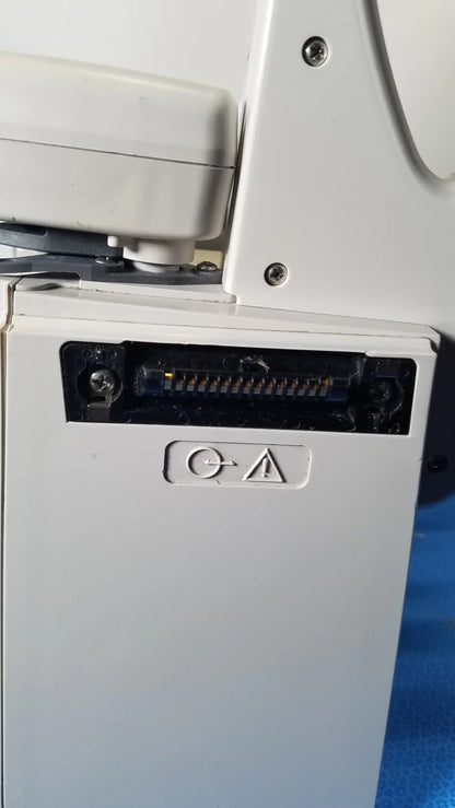Backside of bd alaris 8015 pc pump showing white plastic connector port with black slot and screws for modular infusion medical equipment
