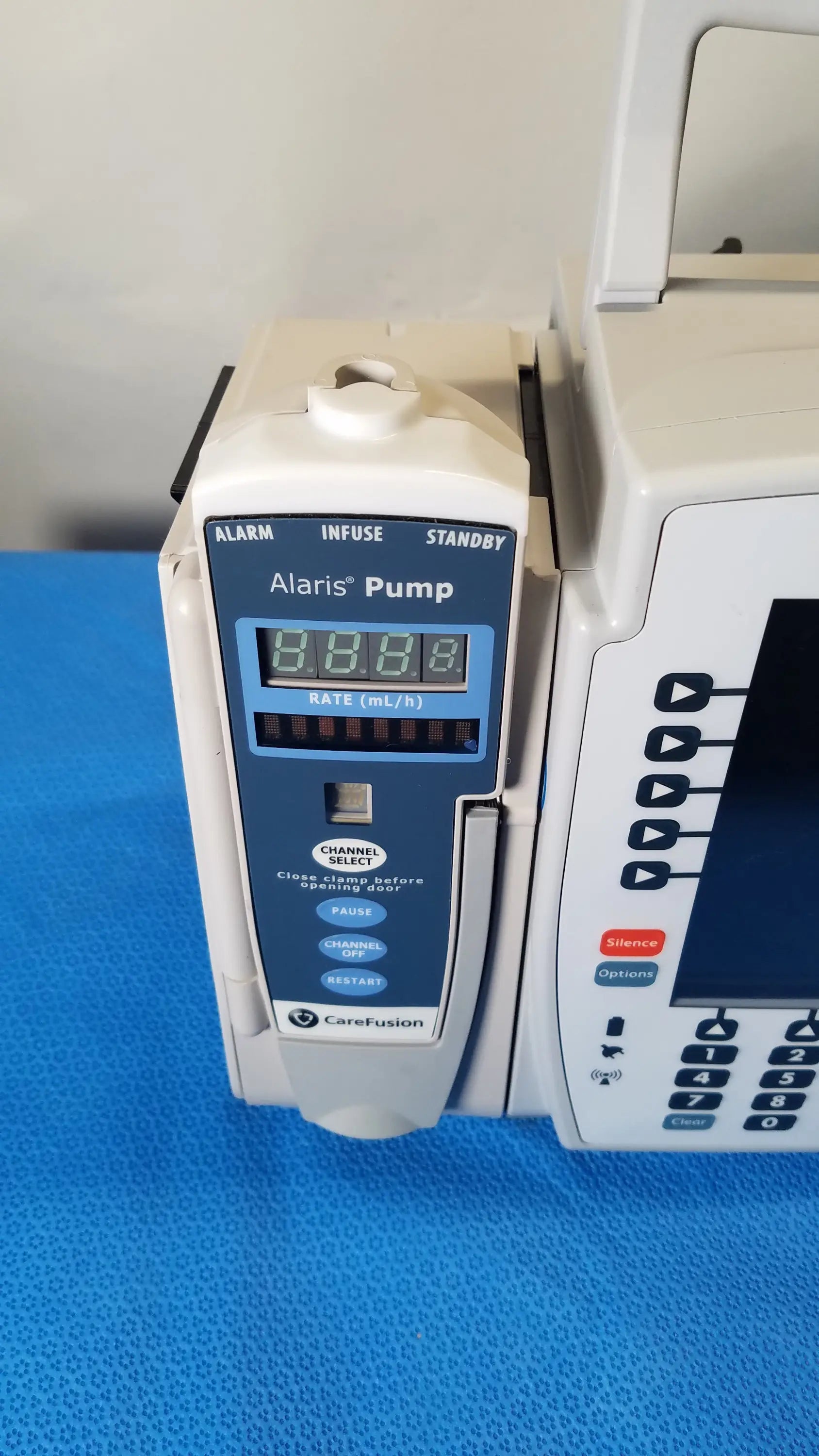 White and blue bd alaris 8015 pc modular infusion pump with digital display showing 8.8.8. for reuse medical equipment