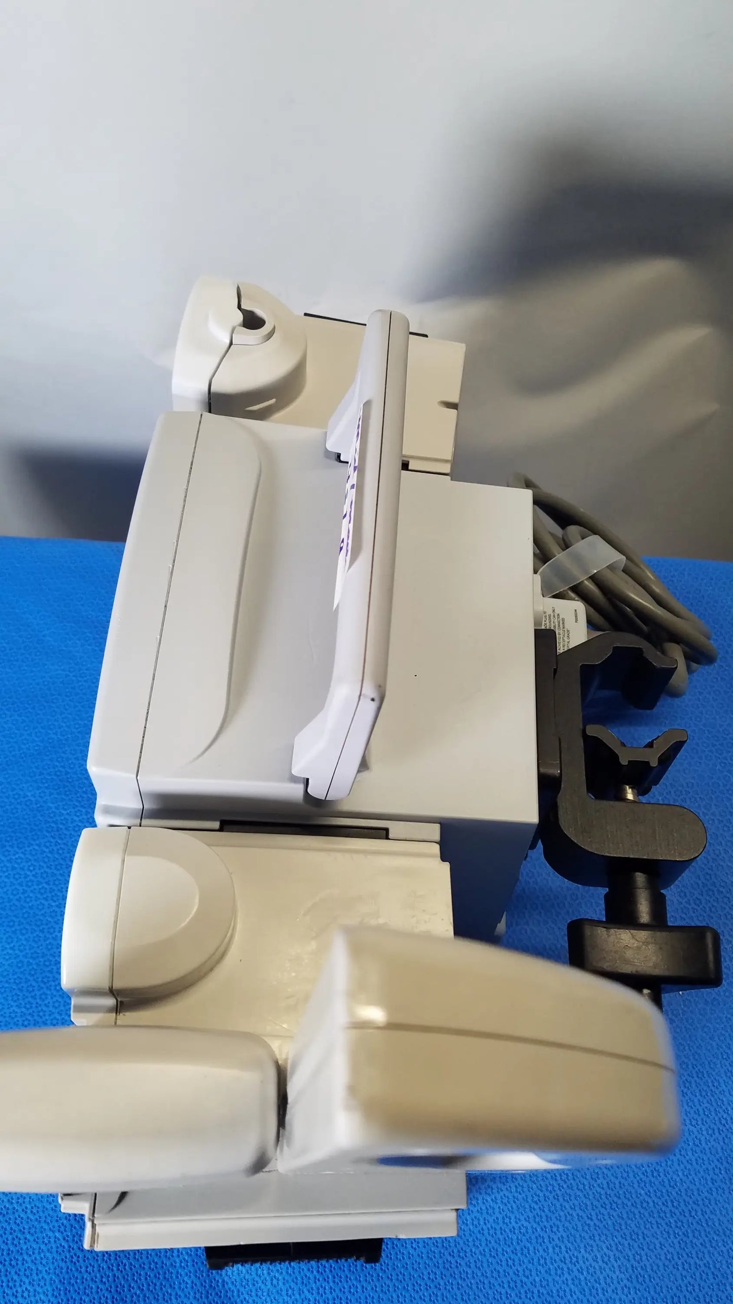 Beige plastic dental chair with integrated armrests and black clamp attachment shown with BD Alaris 8015 PC modular infusion pump