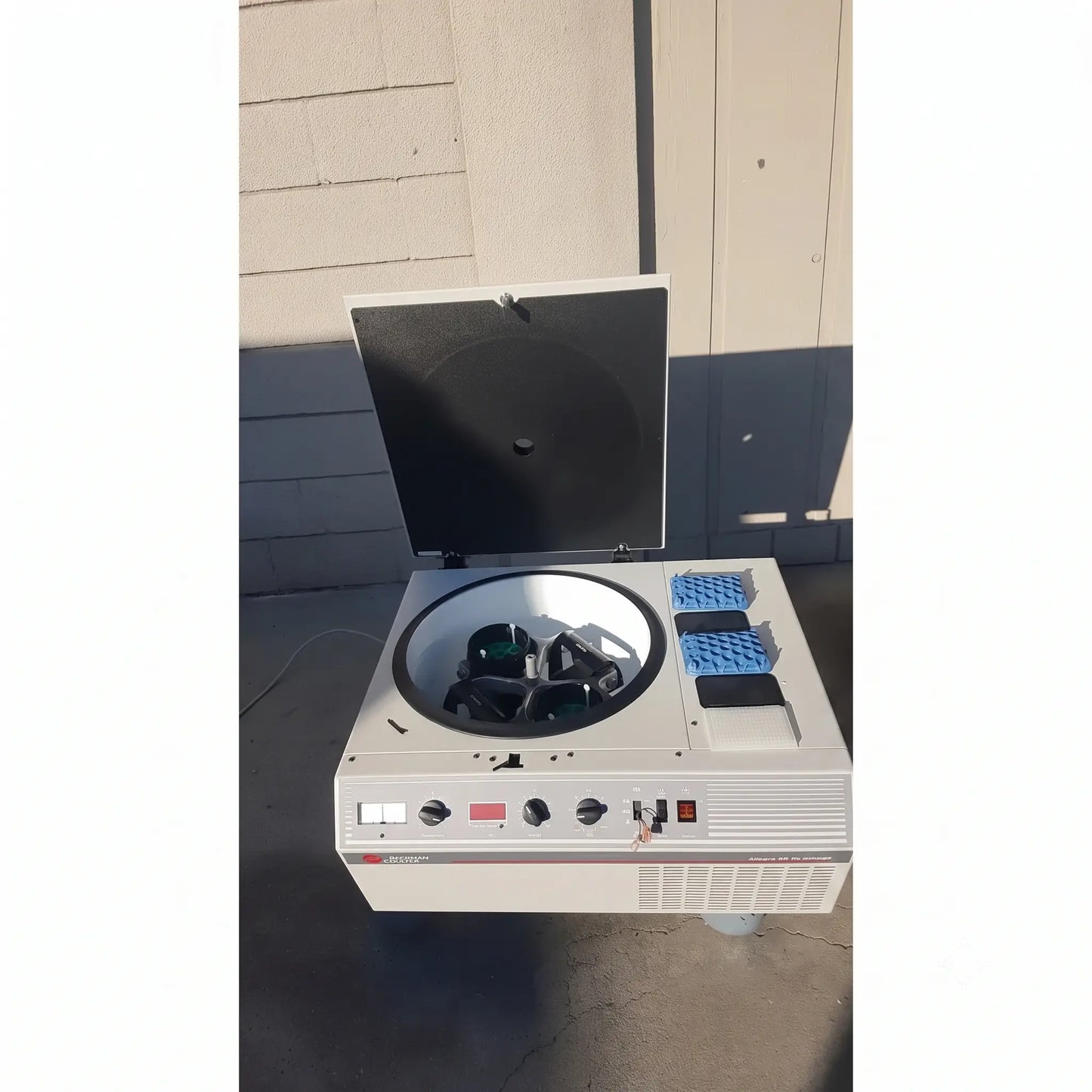 White beckman coulter allegra 6r refrigerated benchtop centrifuge with black lid open showing circular rotor and dark test tubes