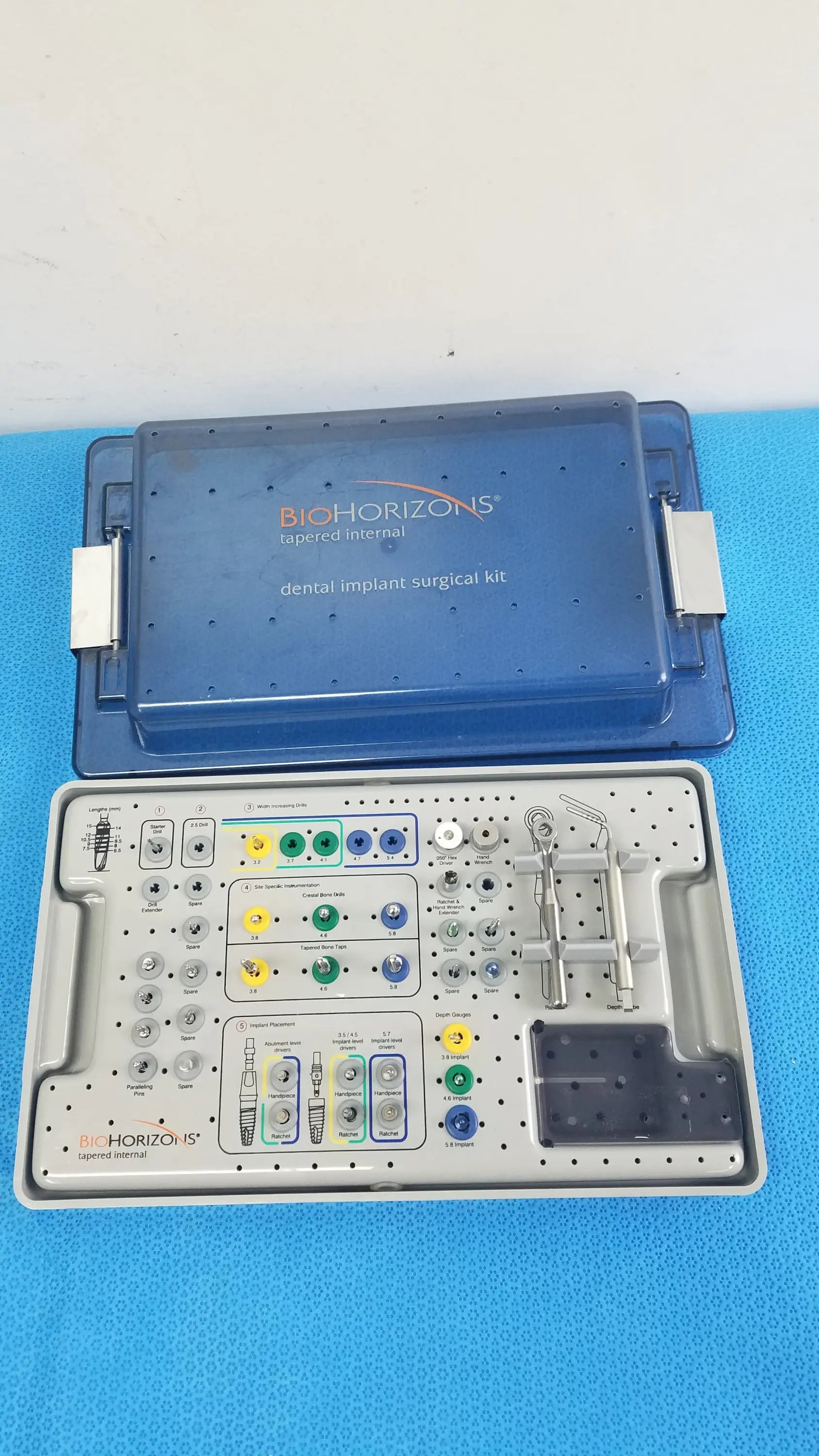 Blue Bio Horizons tapered internal dental implant surgical kit with organized trays holding metallic tools and colored components