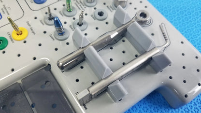 Silver tapered internal dental handpiece with textured grip and measurement markings on gray surgical tray in kit