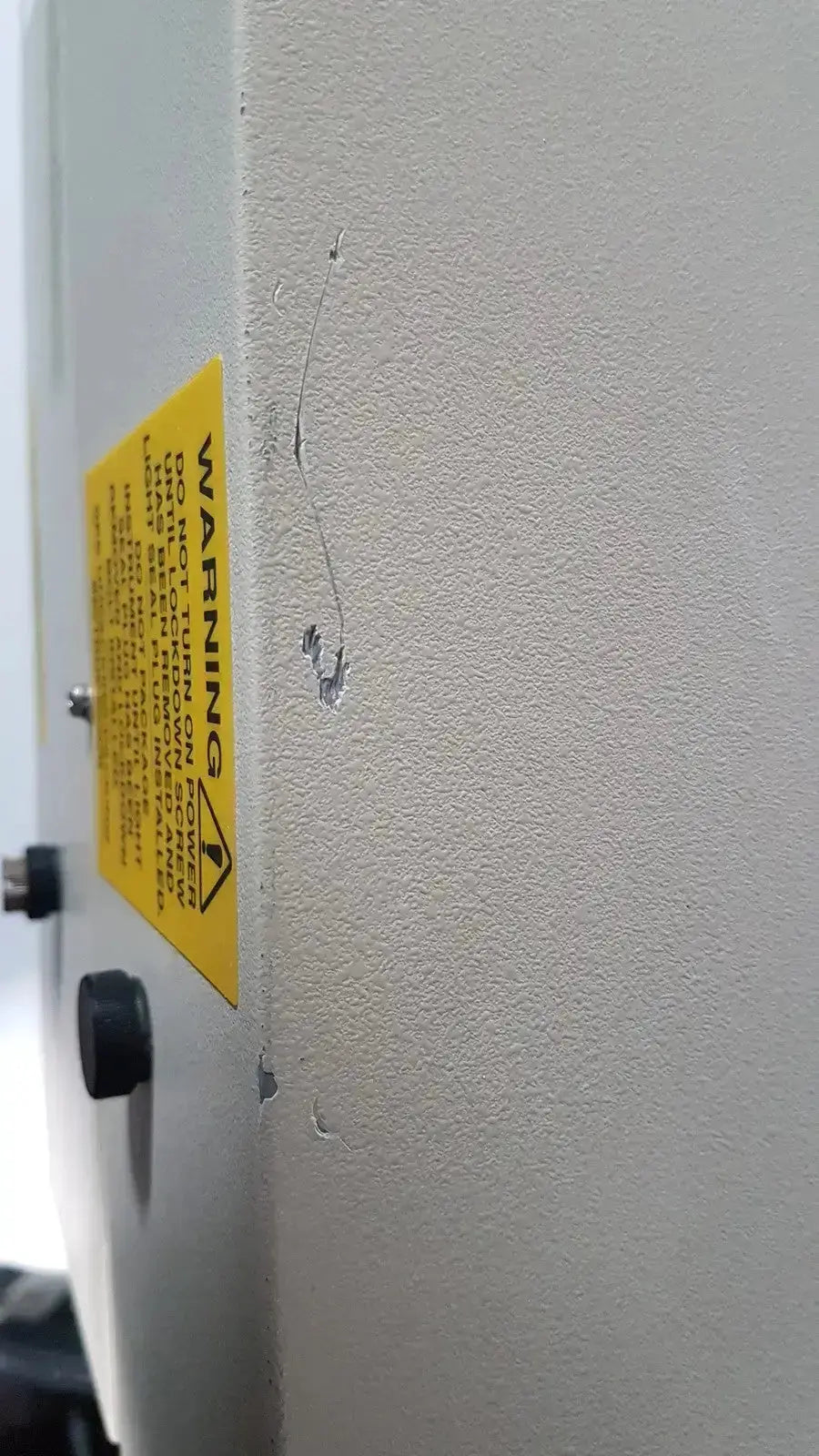 Yellow warning label on textured gray casing of bio rad molecular imager fx industrial imaging device