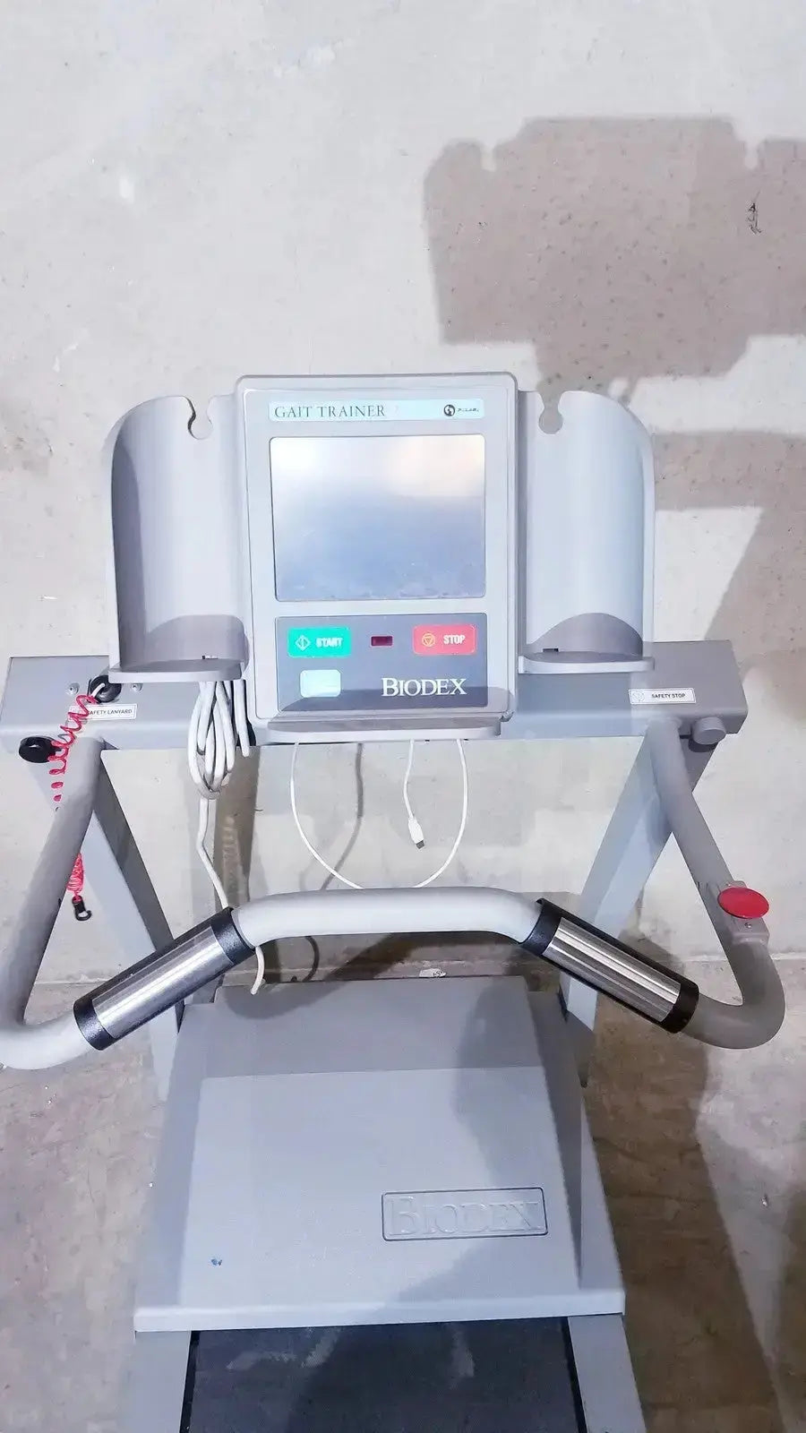 Gray biodex gait trainer ii treadmill with digital display, metallic handrails, and control buttons for rehabilitation