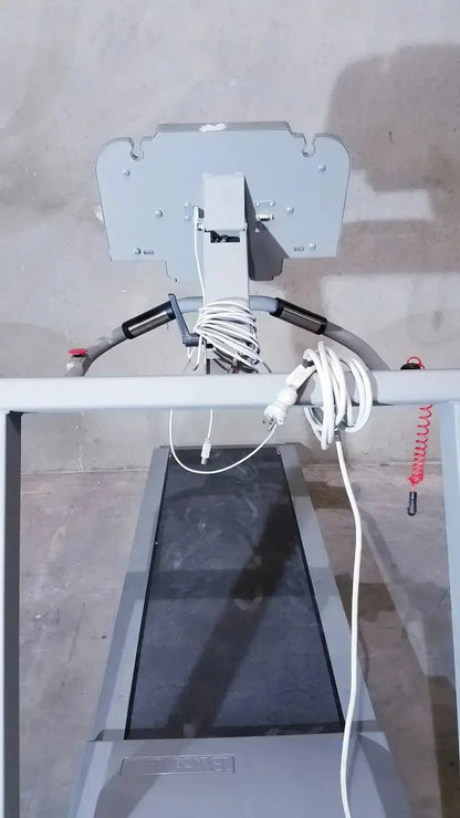 Gray biodex gait trainer ii treadmill with digital display and coiled white cables hanging from its frame