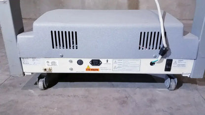 Gray plastic biodex gait trainer ii treadmill showing back side ventilation slits and caster wheels for mobility