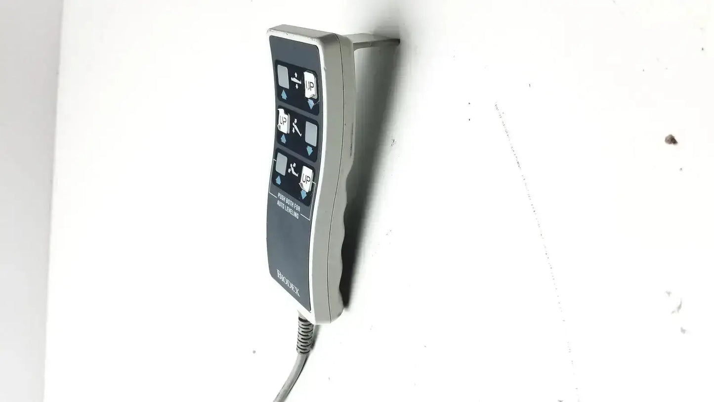Gray wall-mounted Biodex ultrasound table remote controller with curved ergonomic design and coiled cable attached