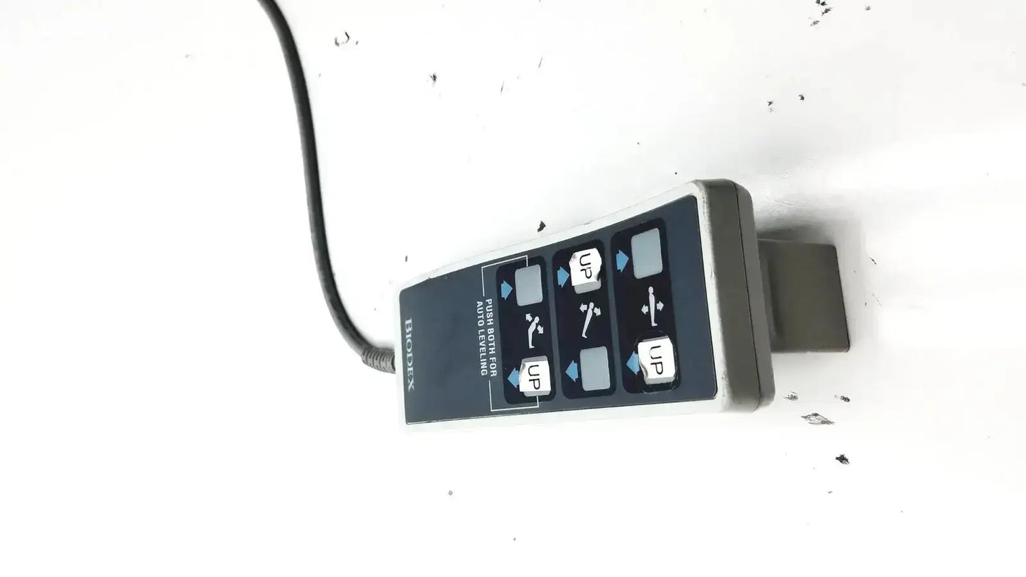 Black and gray handheld remote controller with labeled directional buttons for Biodex ultrasound table use
