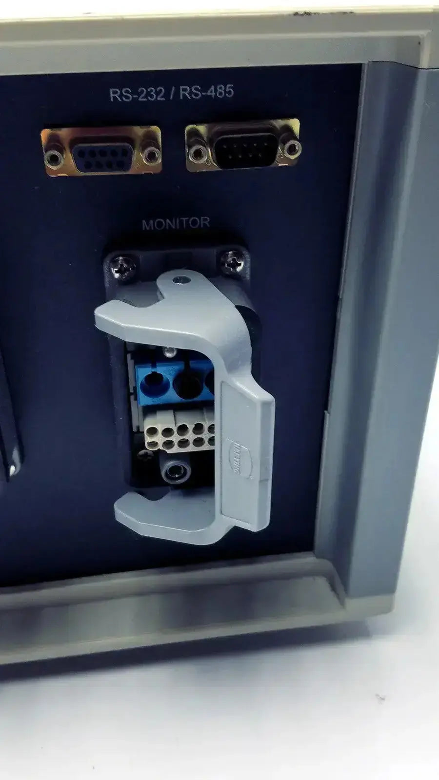 Gray plastic cover with hinged latch securing blue and white terminal blocks on biospherix oxycycler a84xov back side