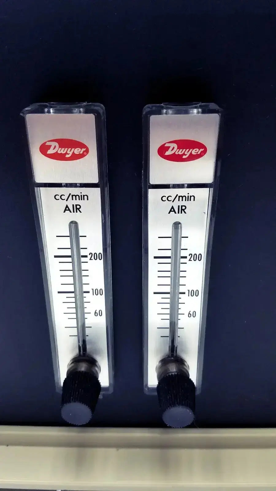 Two identical dwyer air flow meters with clear plastic housing and black knobs for biospherix oxycycler a84xov dynamic use