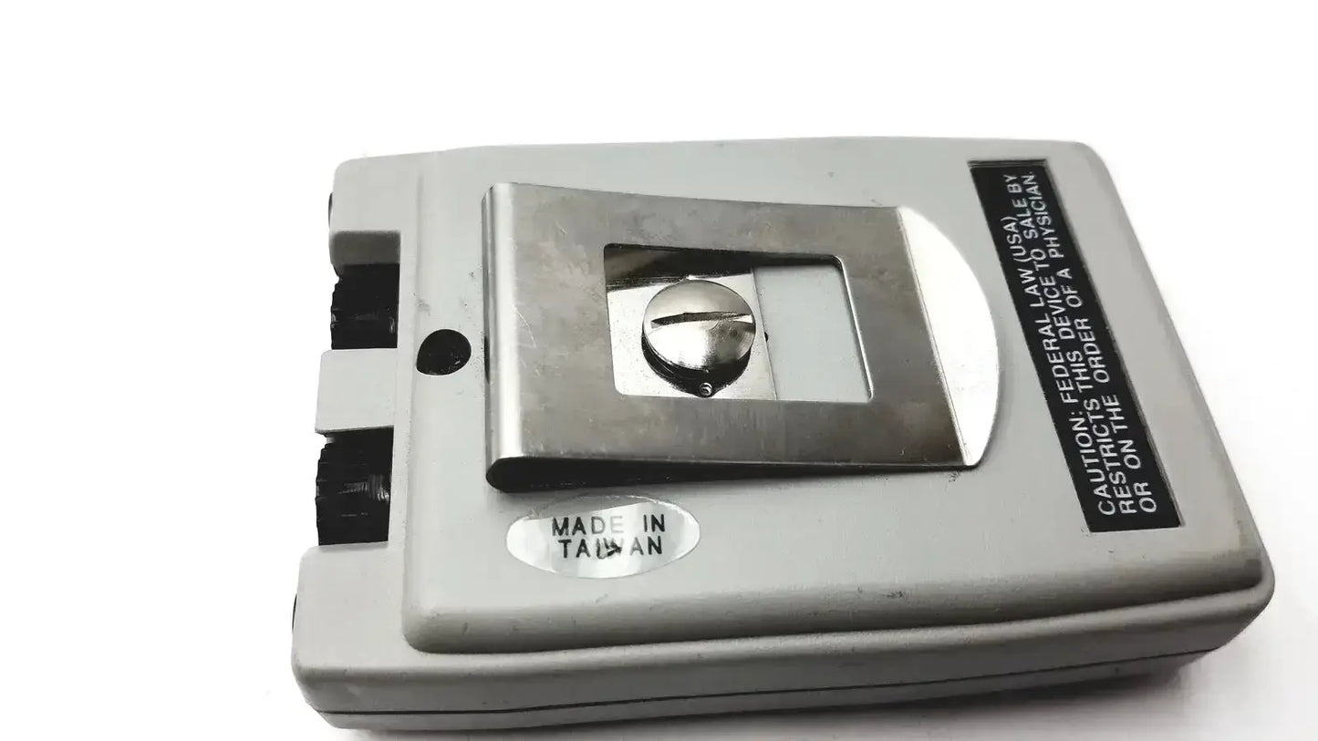 Gray plastic biotens transcutaneous electrical nerve stimulator with metallic silver cassette compartment and regulatory label