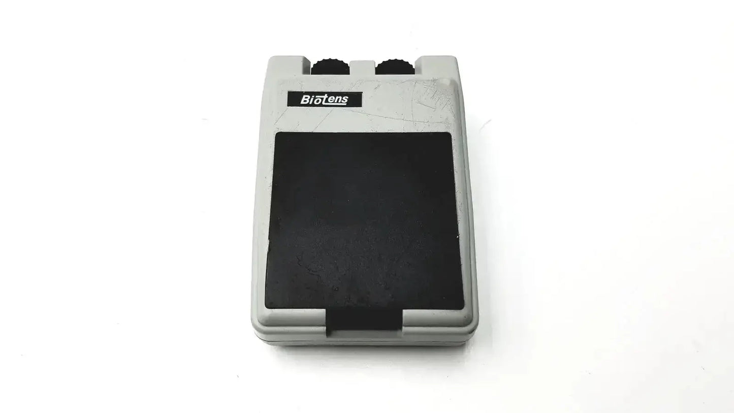 Gray plastic biotens transcutaneous electrical nerve stimulator foot pedal with black rubber top and two black knobs on upper edge
