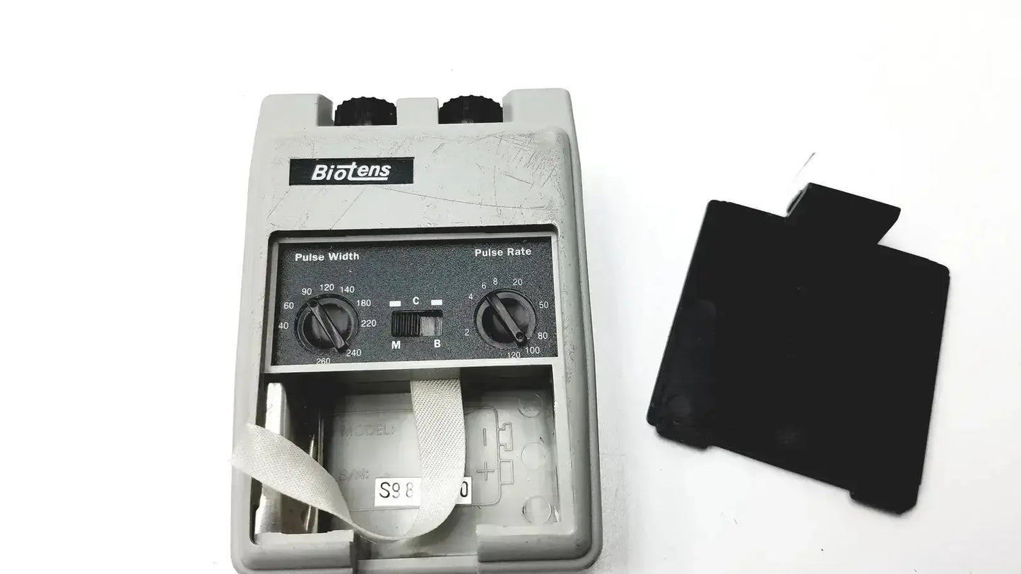 Gray plastic biotens transcutaneous electrical nerve stimulator with black knobs for pulse width and rate and white strap inside housing